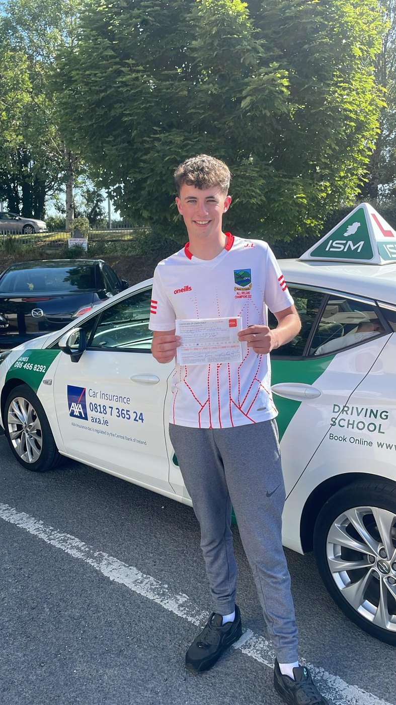 A pupil holding an RSA Certificate of Competency beside James Flynn’s branded school car